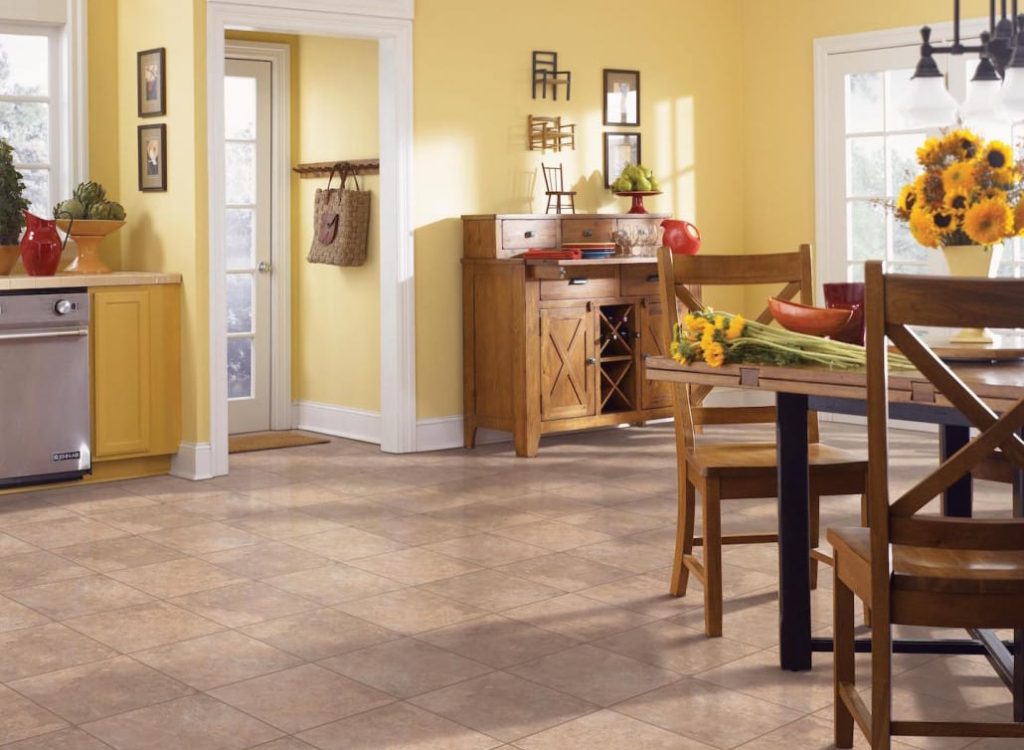 Hardwood 13 A bright yellow kitchen and dining area with light brown tiled floors, wooden furniture, and sunflowers.